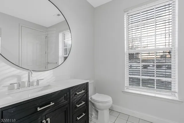 a bathroom with a toilet a sink and a mirror