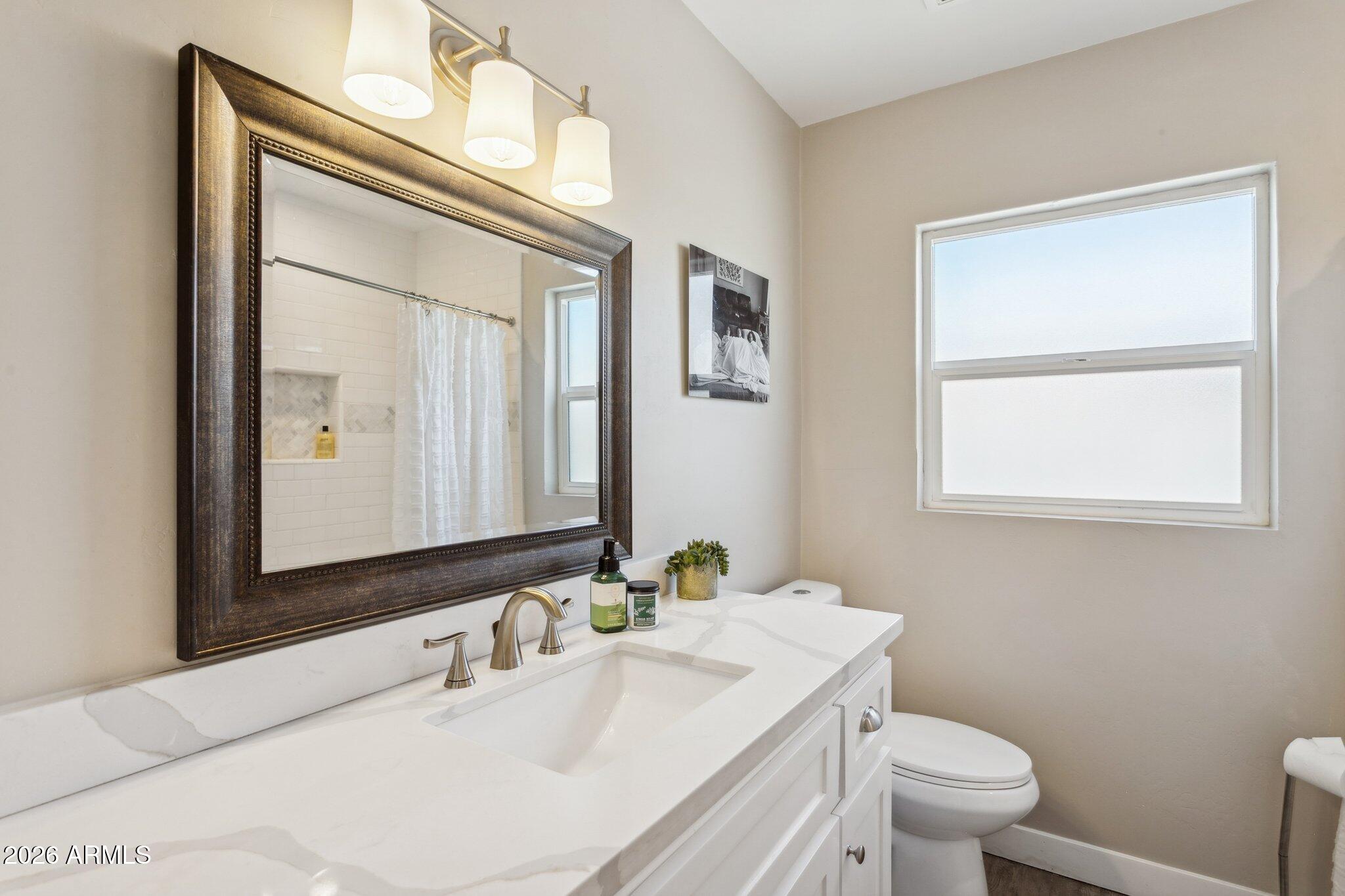 322 West Coronado Road Phoenix, AZ 85003 - Photo 28 of 93 a bathroom with a toilet a sink and mirror
