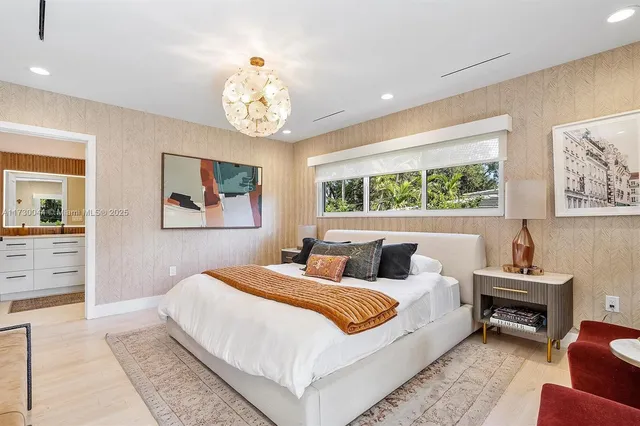 a bedroom with a bed television on desk and a flat screen tv