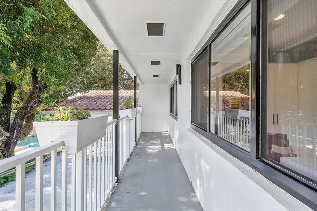 a view of a patio with couches and table and chairs and potted plants