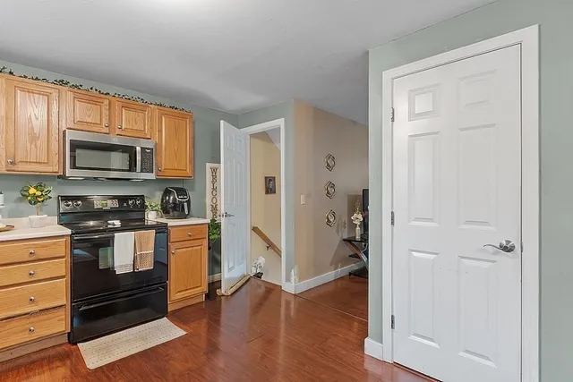 a kitchen with stainless steel appliances and wooden floor