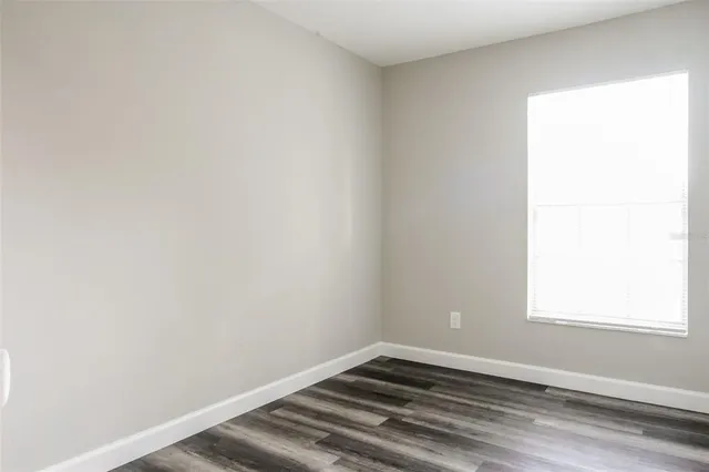 a view of a small space with wooden floor and a window