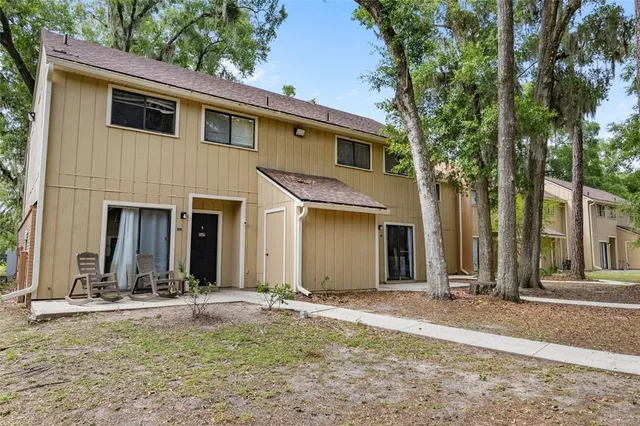 a view of a house with backyard and trees