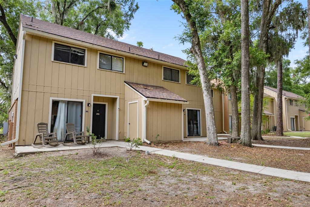a view of a house with backyard and trees