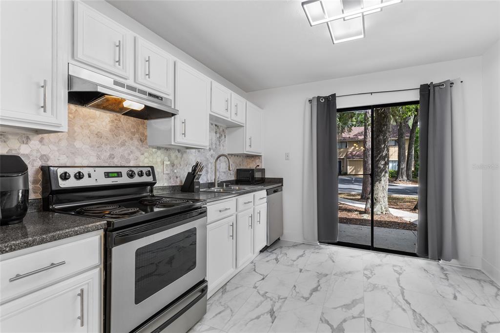 507 Northwest 39th Road, Unit 320 Gainesville, FL 32607 - Photo 11 of 33 a kitchen with stainless steel appliances granite countertop a stove sink and cabinets