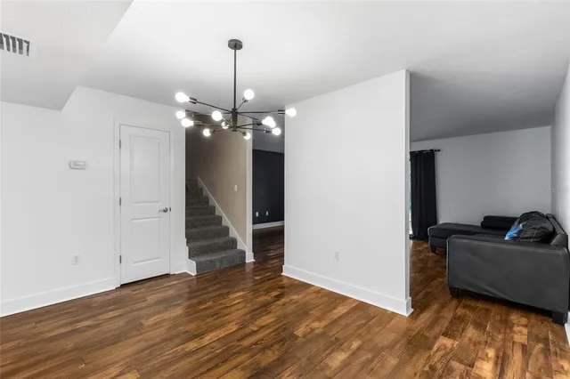 a view of a livingroom with wooden floor and staircase