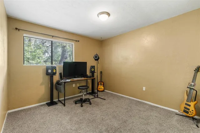 a view of a workspace with furniture and a window