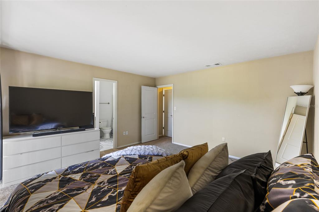 507 Northwest 39th Road, Unit 320 Gainesville, FL 32607 - Photo 24 of 33 a bedroom with a bed and a flat screen tv