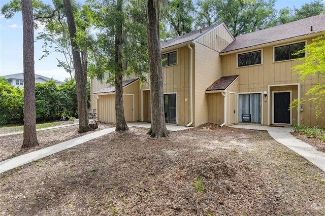 a view of a house with backyard and a tree
