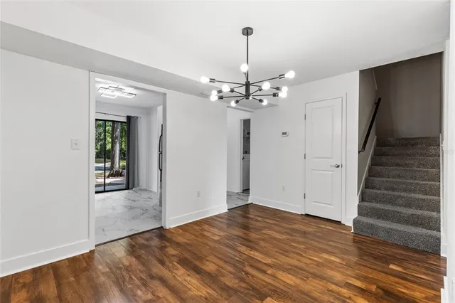 a view of a livingroom with wooden floor and staircase