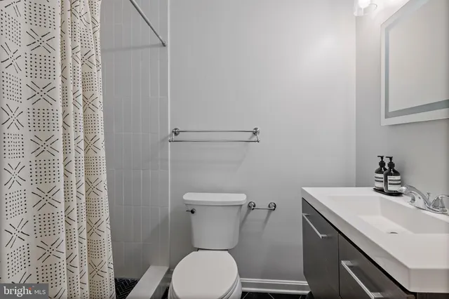 a bathroom with a sink toilet and a mirror