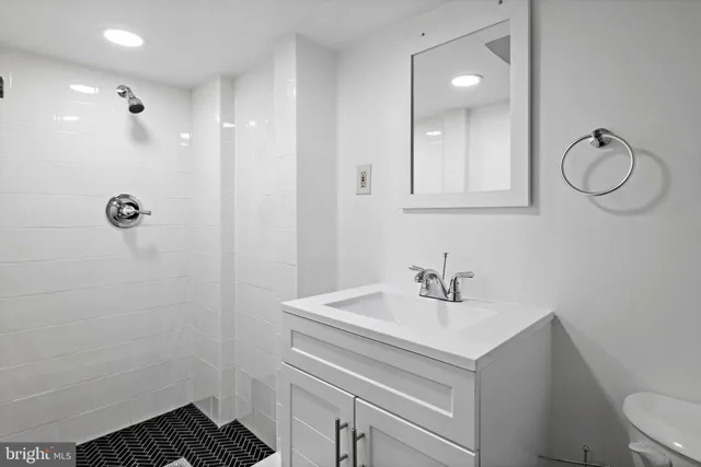 a bathroom with a sink toilet and a mirror