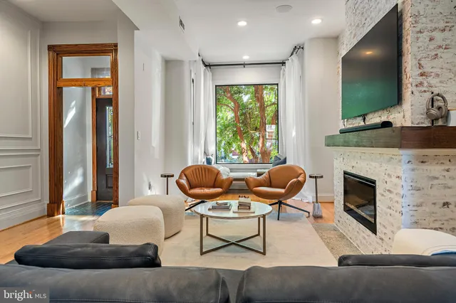 a living room with furniture a flat screen tv and a fireplace