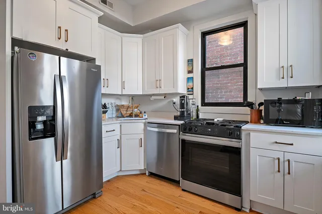 a kitchen with white cabinets and stainless steel appliances