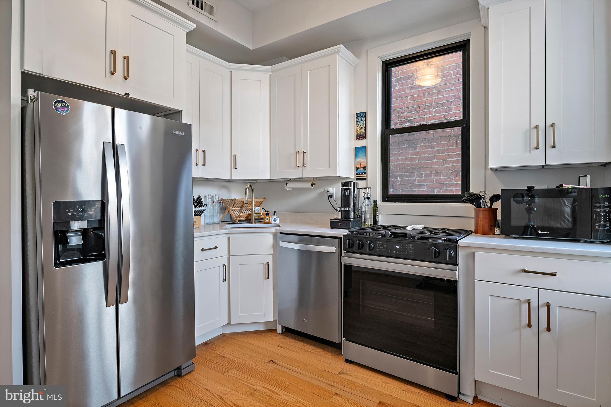 55 S Street Northwest Washington, DC 20001 - Photo 6 of 25 a kitchen with white cabinets and stainless steel appliances