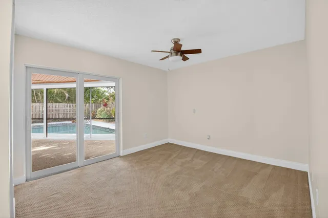 an empty room with a sliding door and a ceiling fan