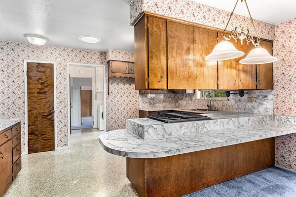 a kitchen with stainless steel appliances granite countertop a stove a sink and a microwave