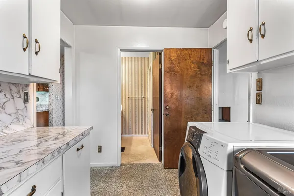 a bathroom with a granite countertop sink and a bathtub