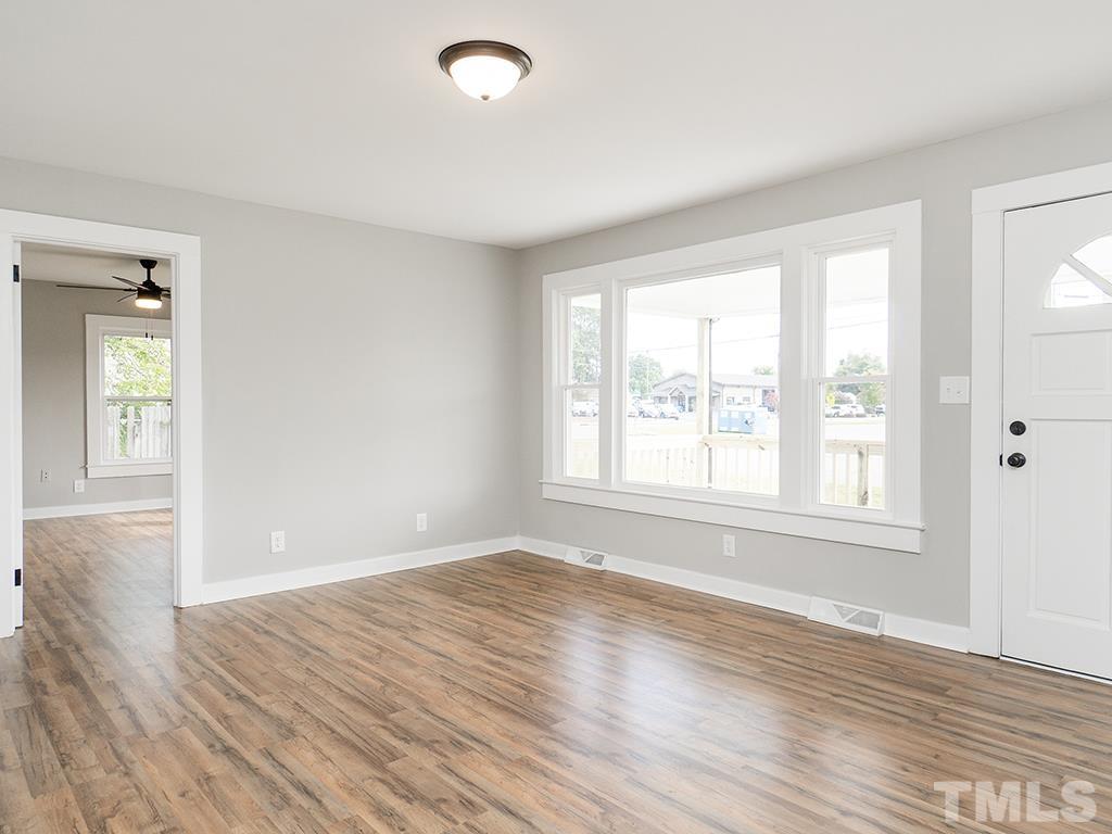 1235 South Main Street Graham, NC 27253 - Photo 11 of 33 an empty room with wooden floor and windows
