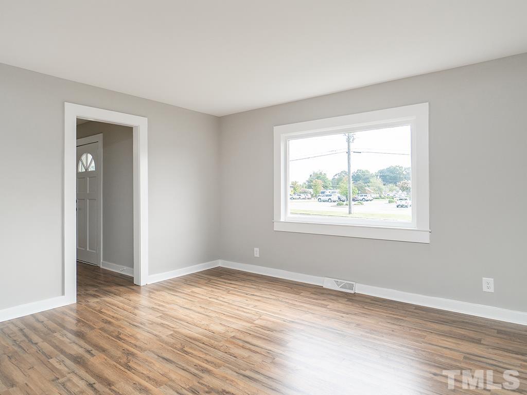 1235 South Main Street Graham, NC 27253 - Photo 12 of 33 an empty room with wooden floor and windows