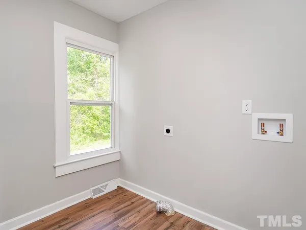 an empty room with wooden floor and a window