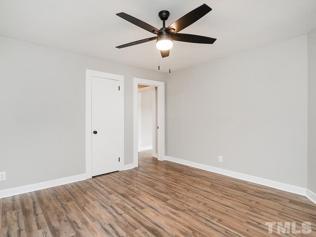 1235 South Main Street Graham, NC 27253 - Photo 17 of 33 an empty room with wooden floor and ceiling fan