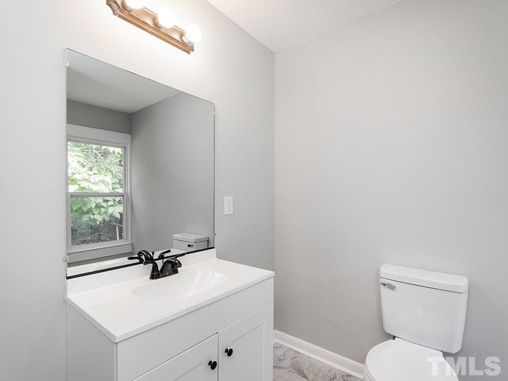 1235 South Main Street Graham, NC 27253 - Photo 18 of 33 a bathroom with a toilet a sink and mirror