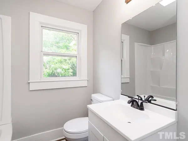 a bathroom with a sink toilet vanity and mirror
