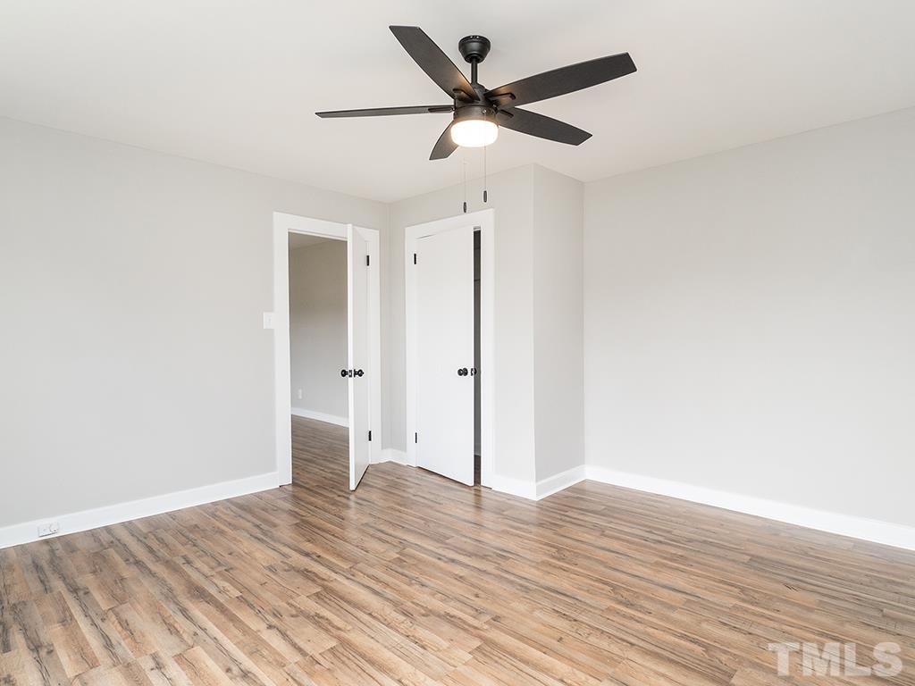 1235 South Main Street Graham, NC 27253 - Photo 24 of 33 an empty room with wooden floor and a ceiling fan