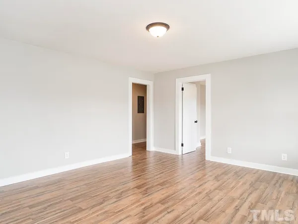a view of an empty room with wooden floor