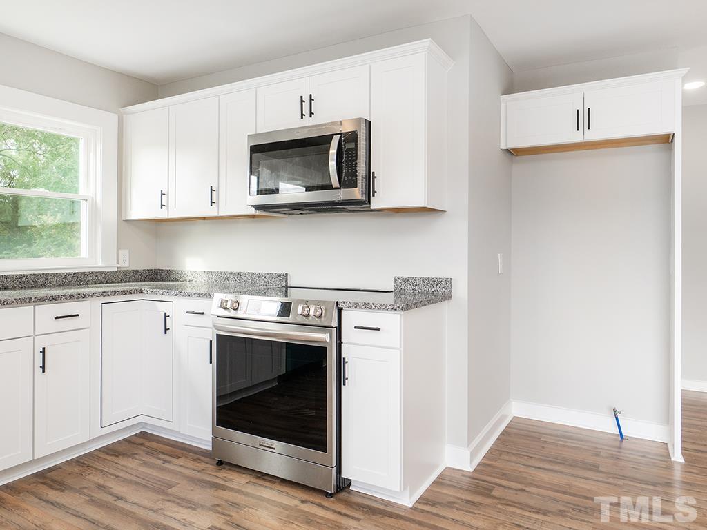 1235 South Main Street Graham, NC 27253 - Photo 6 of 33 a kitchen with a stove and a microwave