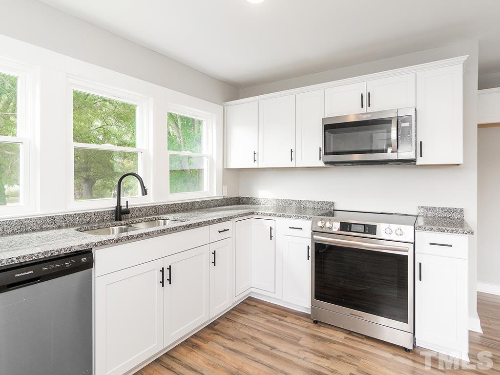 1235 South Main Street Graham, NC 27253 - Photo 8 of 33 a kitchen with stainless steel appliances granite countertop white cabinets a sink and a stove