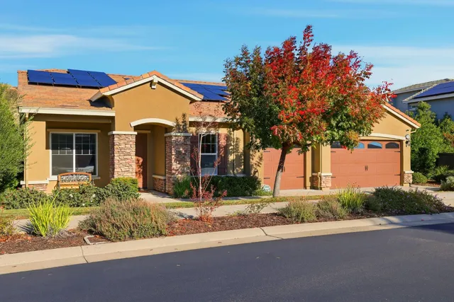 a view of a house with a small yard and potted plants