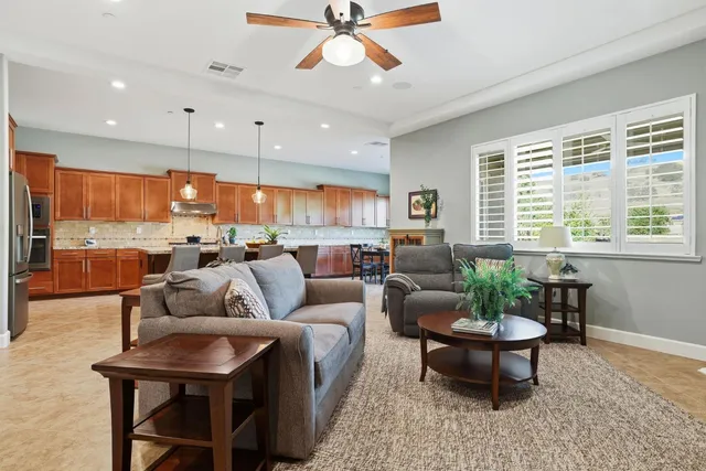 a living room with furniture kitchen view and a large window