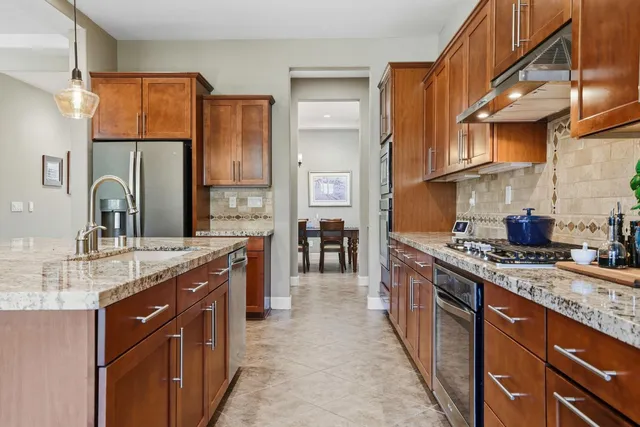 a kitchen with stainless steel appliances granite countertop a sink stove and refrigerator