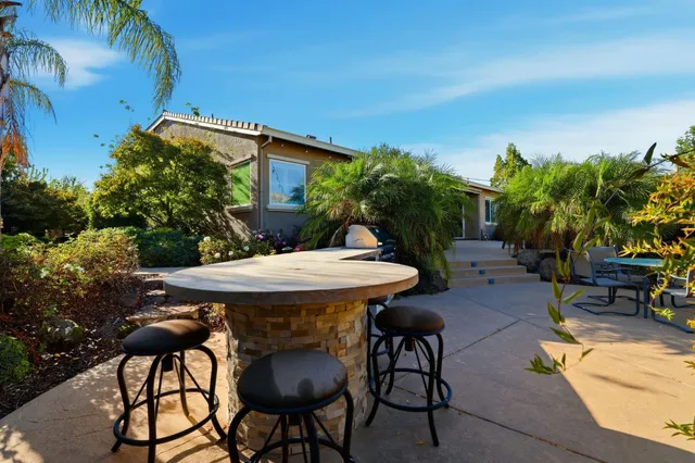a view of a backyard with table and chairs and potted plants