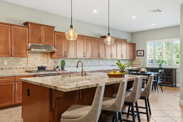 a kitchen with a dining table chairs sink and cabinets