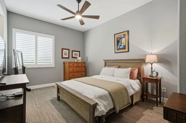 a bedroom with a bed and a lamp on dresser