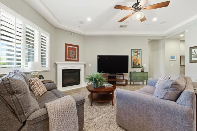 a living room with furniture a fireplace and a flat screen tv