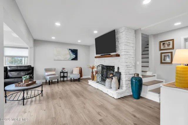 a living room with furniture a fireplace a flat screen tv and kitchen view