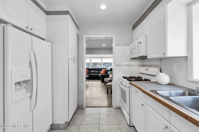a kitchen with white cabinets and appliances