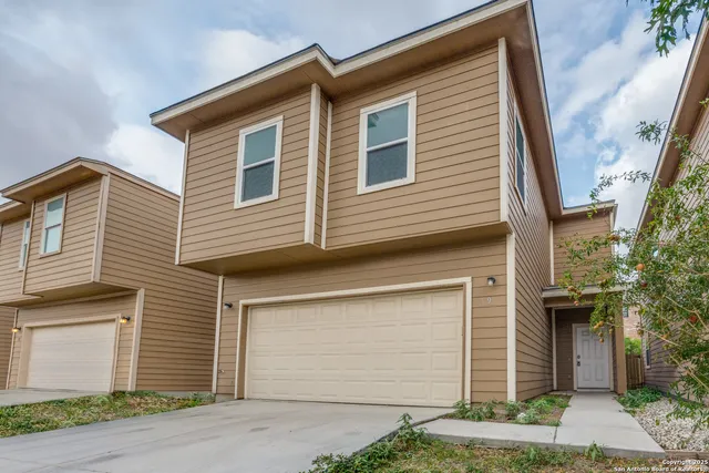 a view of a house with a yard and garage