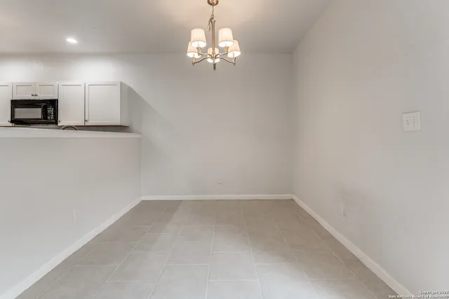 a view of a kitchen with a sink and chandelier