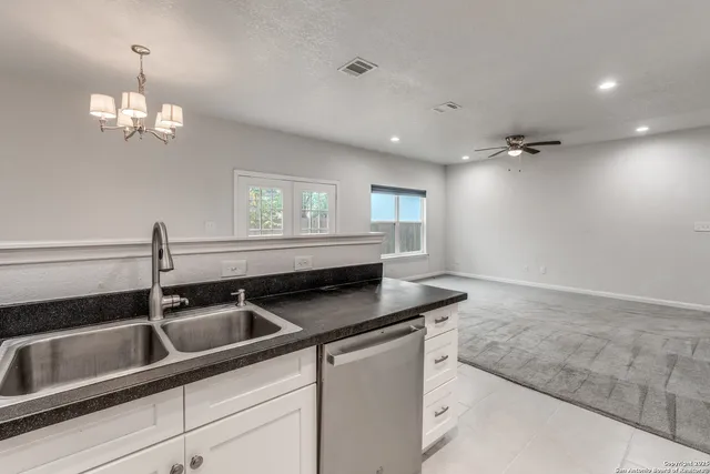 a kitchen with granite countertop a sink stove and refrigerator