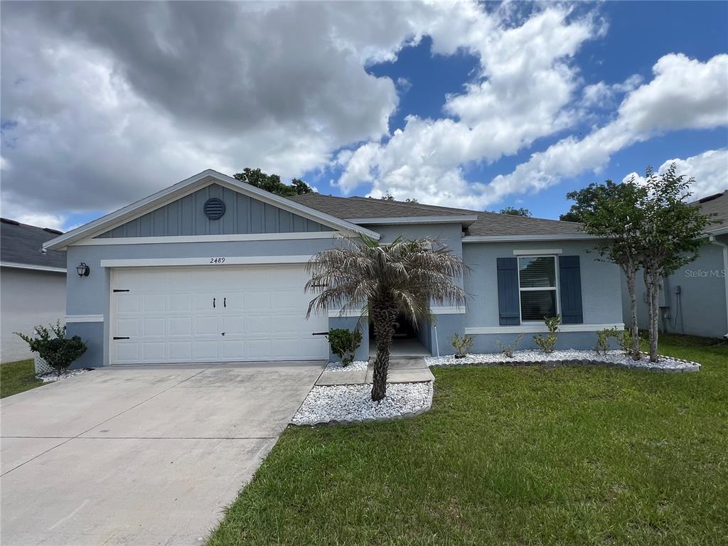 2489 Bulrush Drive St. Cloud, FL 34769 - Photo 1 of 22 a view of a house with a yard and potted plants