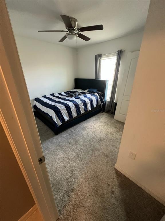 2489 Bulrush Drive St. Cloud, FL 34769 - Photo 14 of 22 a bedroom with a bed and a ceiling fan