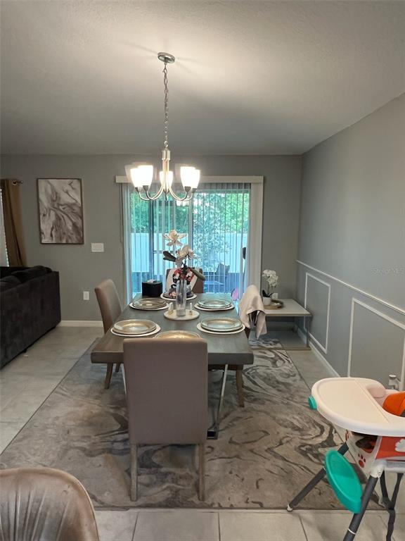 2489 Bulrush Drive St. Cloud, FL 34769 - Photo 6 of 22 a living room with a couch and a chandelier