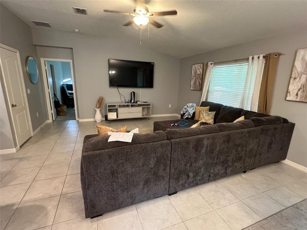 2489 Bulrush Drive St. Cloud, FL 34769 - Photo 9 of 22 a living room with couches and a flat screen tv