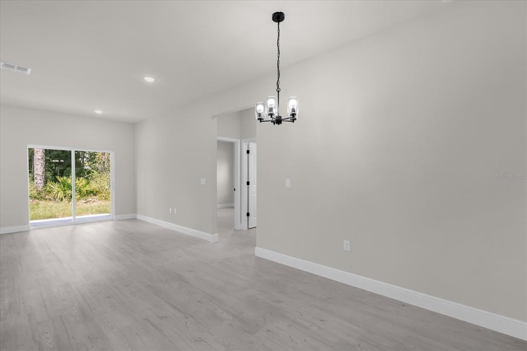 15782 Southwest 52nd Ave Road Ocala, FL 34473 - Photo 5 of 34 a view of a room with window wooden floor chandelier and glass door