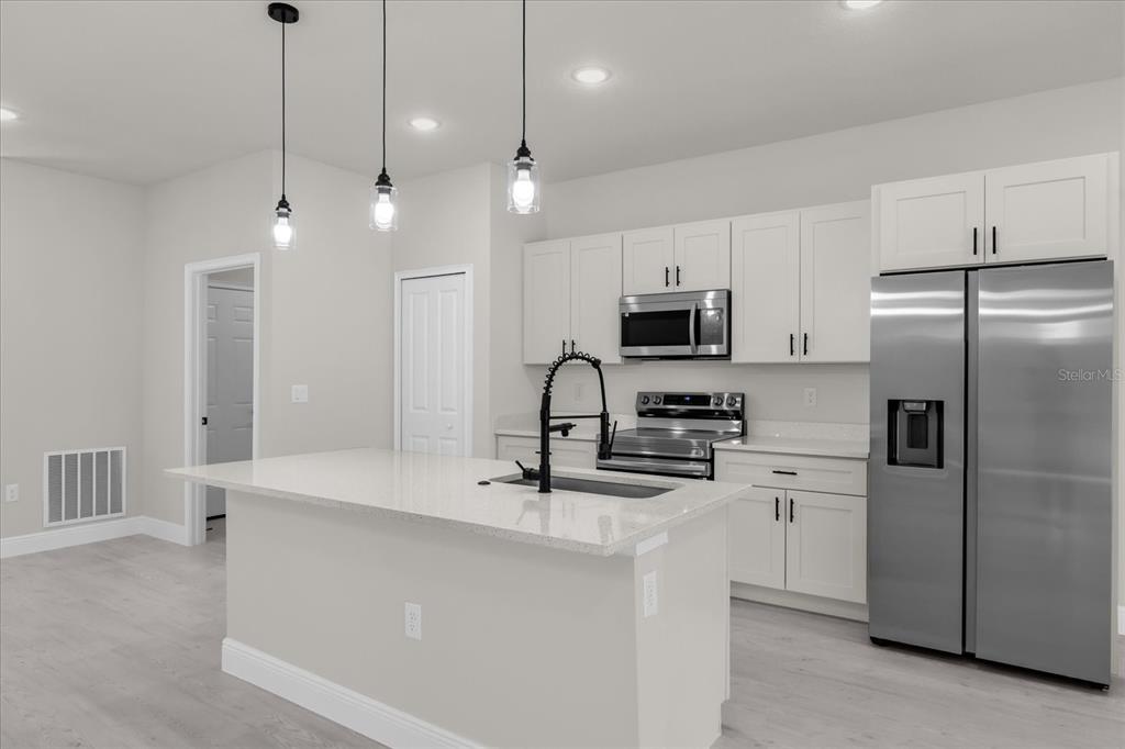 15782 Southwest 52nd Ave Road Ocala, FL 34473 - Photo 9 of 34 a kitchen with kitchen island a sink stainless steel appliances and cabinets